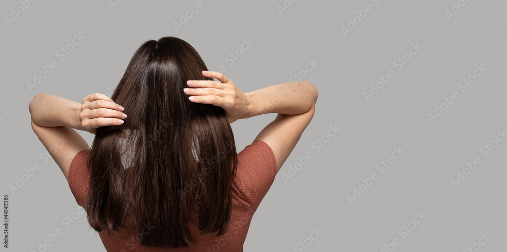 Banner with turned back girl touching her hair on light background Banner with turned back girl touching her hair on light background