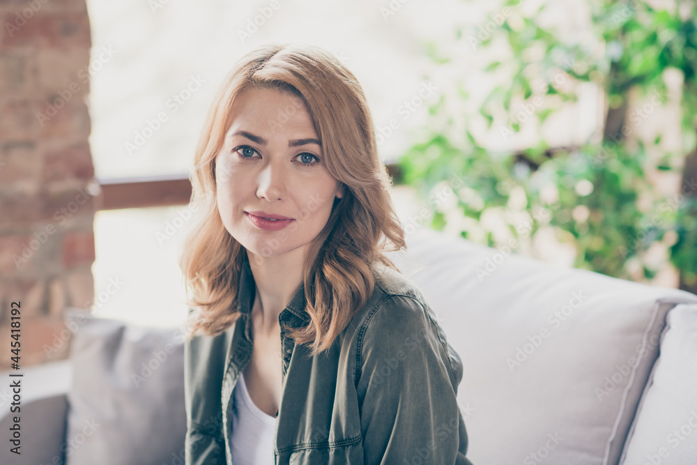 Portrait of attractive cute wavy-haired woman sitting on divan spending weekend staying at home house indoors Portrait of attractive cute wavy-haired woman sitting on divan spending weekend staying at home house indoors