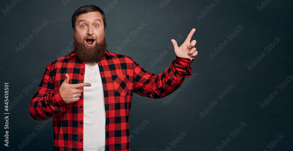 Impressed and wondered good-looking caucasian male model in modern red checkered shirt, gasping amused say wow fascinated, pointing right curious, found interesting product and gather info about it Impressed and wondered good-looking caucasian male model in modern red checkered shirt, gasping amused say wow fascinated, pointing right curious, found interesting product and gather info about it