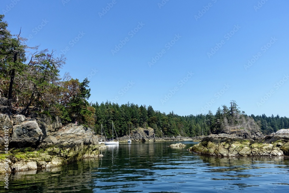 The view of an opening or entrance to a beautiful cove with boats anchored.  This is Smugglers Cove, Sunshine Coast, British Columbia, Canada