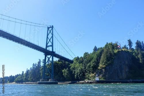A view of Lions Gate Bridge and the seawall in Stanley Park, Vancouver, British Columbia, Canada from the ocean on a beautiful sunny summer day