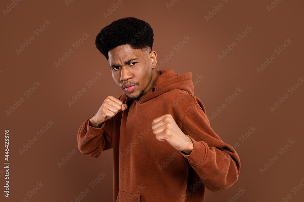 Photo of strict brunet hairdo young guy boxing dress sportswear isolated on brown color background Photo of strict brunet hairdo young guy boxing dress sportswear isolated on brown color background