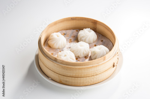 Chinese dim sum dumplings in bamboo basket isolated on white background