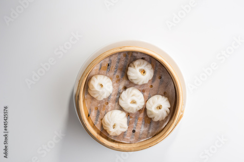 Chinese dim sum dumplings in bamboo basket isolated on white background