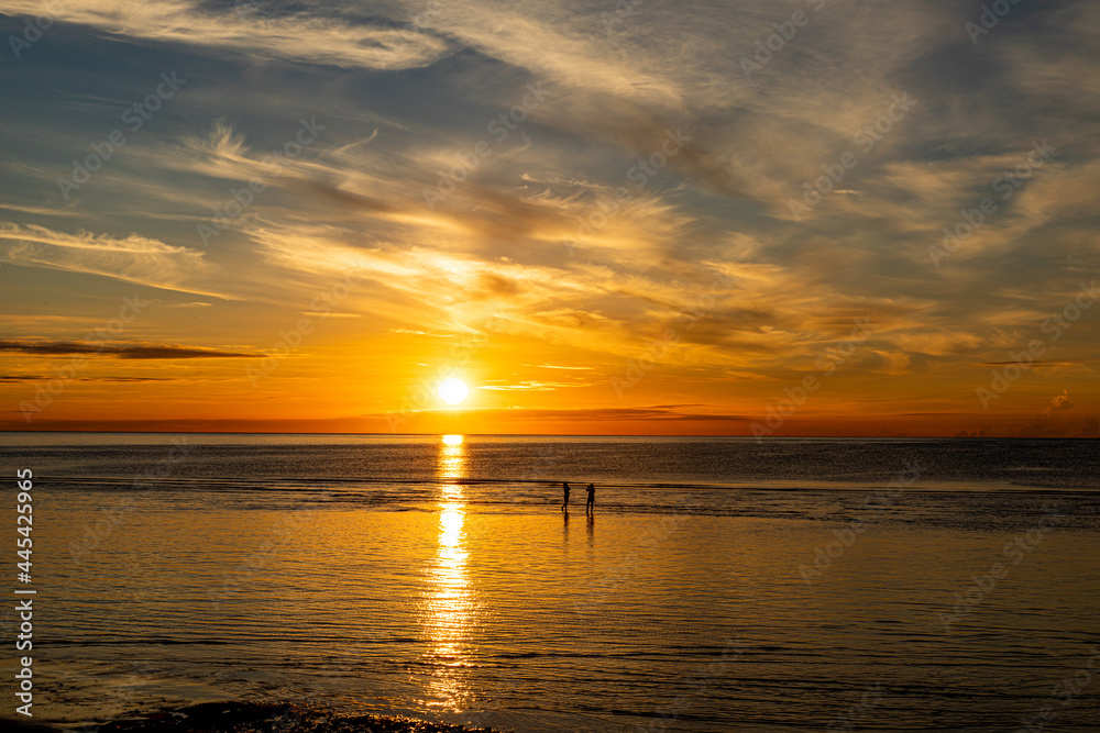 Silhouette, Tourists stand to take pictures on the beach of Hua Hin morning sunrise