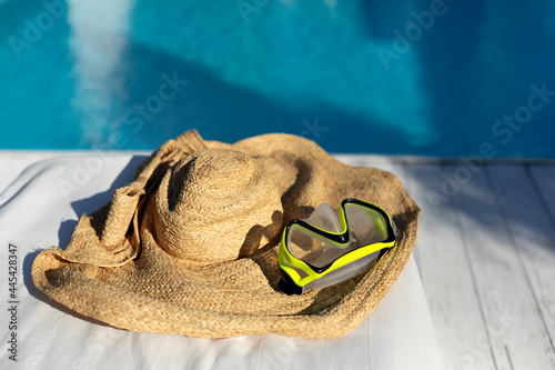 Swimming goggles on jute hat at poolside photo
