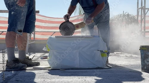 Man cuts a marble slab with the rotary saw in slowmotion photo