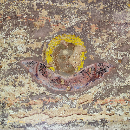the remains of the painting of the walls of an abandoned temple are in terrible condition