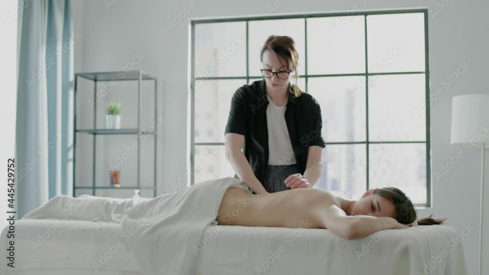 Calm patient lies on table while therapists does massage