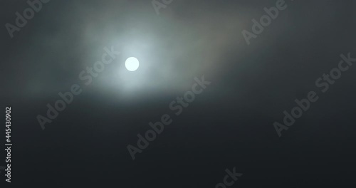 Sun covered by black clouds of smoke. Sunset over clouds. Smoke, fog.
