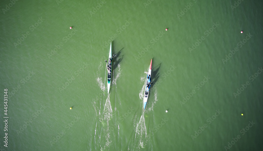 Aerial view of two boats sculling across rowing canal