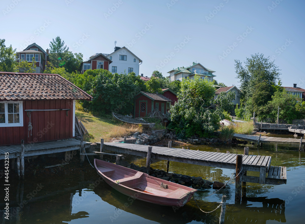 Creek in the archipelago in Stockholm with jetty rowboats and old wood houses Creek in the archipelago in Stockholm with jetty rowboats and old wood houses