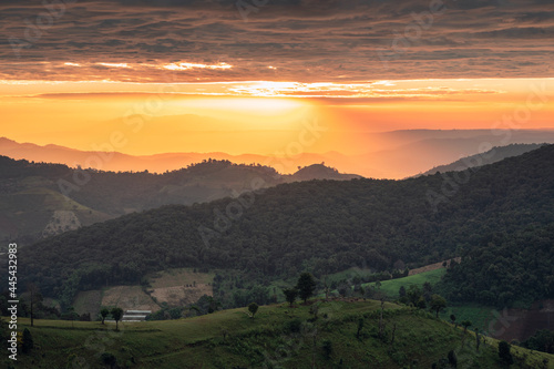 Scenery of colorful sunrise over mountain farmland in countryside