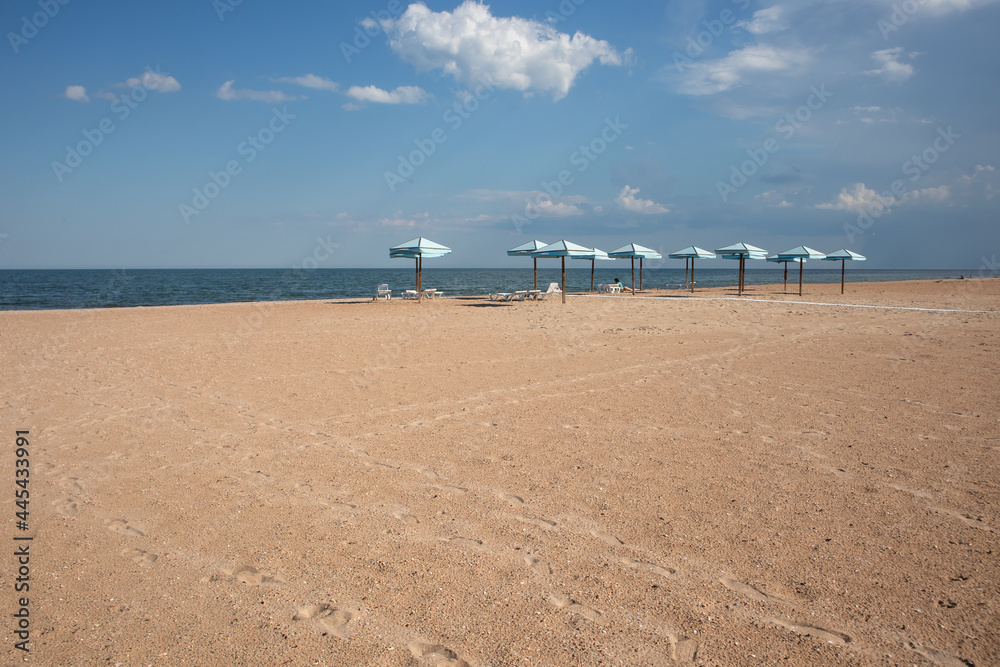 Beach umbrellas on sandy beach and sea background. Summer, travel, beach vacation concept. Beach umbrellas on sandy beach and sea background. Summer, travel, beach vacation concept.