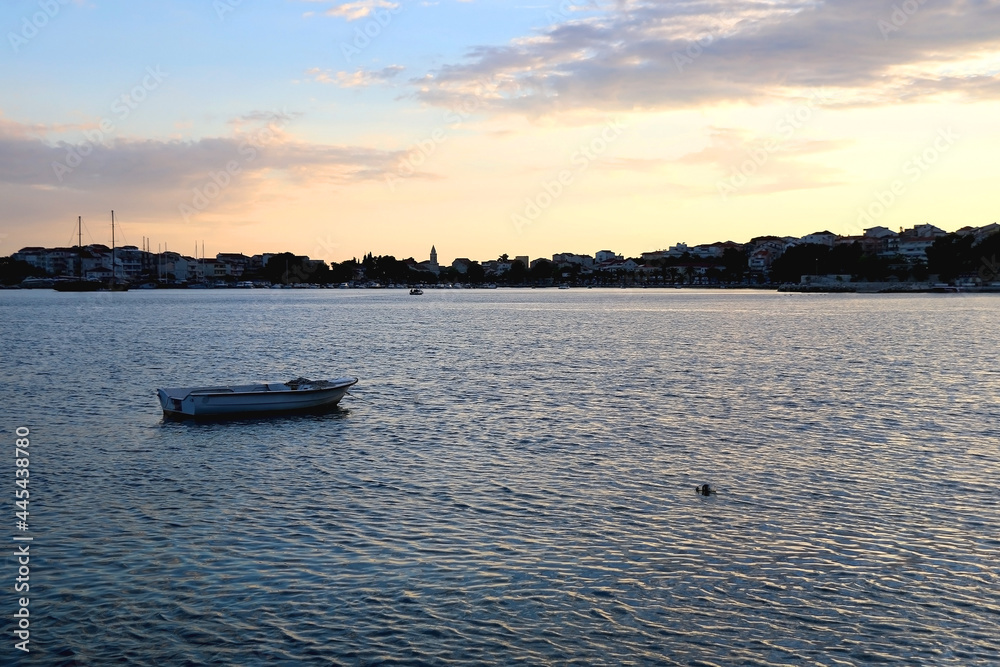 Small boat and beautiful sunset over Stobrec, Croatia.