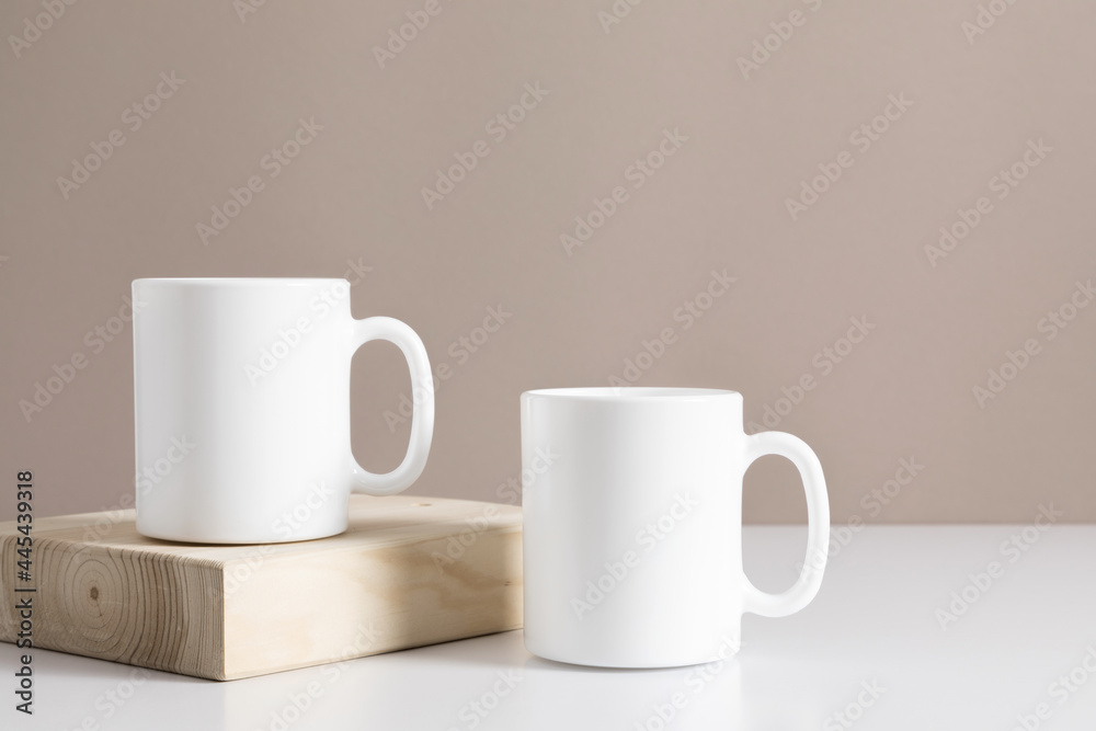 Two mugs mockup on beige table. Front view. Place for text, copy space, mockup Two mugs mockup on beige table. Front view. Place for text, copy space, mockup