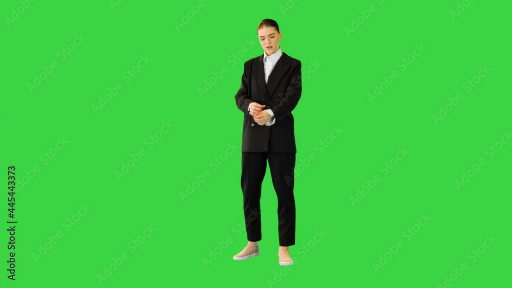 Young woman adjusting her office suit, crossing arms, putting hand on hip on a Green Screen, Chroma Key.