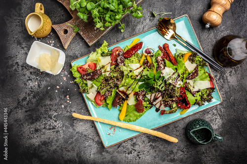 Veal salad with lettuce, parmesan cheese and sun dried tomatoes. Restaurant food, Meat salad. banner, menu recipe place for text, top view