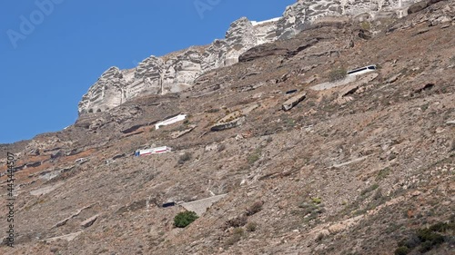 Traffic on dangerous curved road from ferry port to Santorini island carved on caldera clif photo