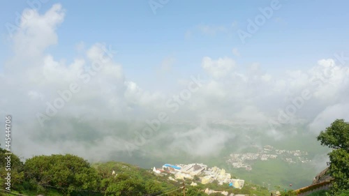 4k Footage. Timelapse of the clouds cover Neminath Jain temple and Junagadh city, View from Girnar hills . A sea of fog is formed over city. Foggy valley mount ridge nature  photo