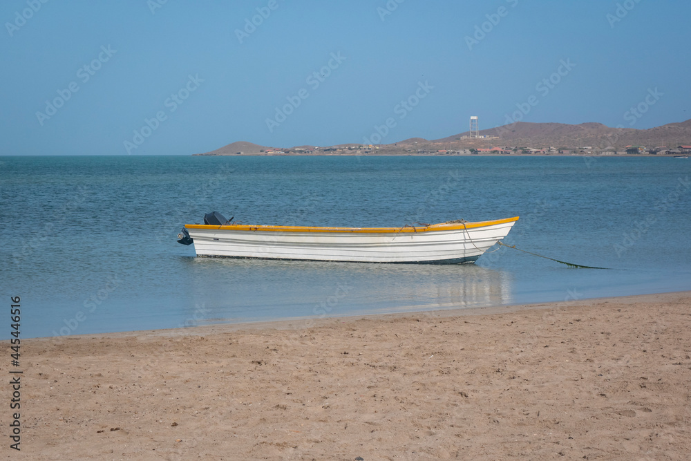 White and Yellow Motor Boat Standing on the Shore of Mayapo Beach, in Uribia, La Guajira, Colombia