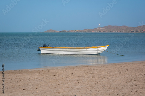 Obraz na płótnie White and Yellow Motor Boat Standing on the Shore of Mayapo Beach, in Uribia, La Guajira, Colombia w salonie