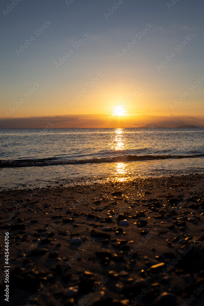 Beautiful Sunrise at the Beach with small Waves without people and sharp clean horizon Upright, Island of Kos, Greece