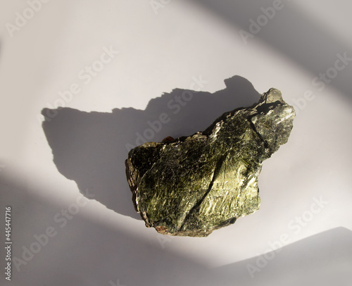 Shiny green muscovite mica mineral sheet on white background. Found in Miass, Ural, Russia. For geology mineralogy magazines websites article, Natural Science museum wall chart