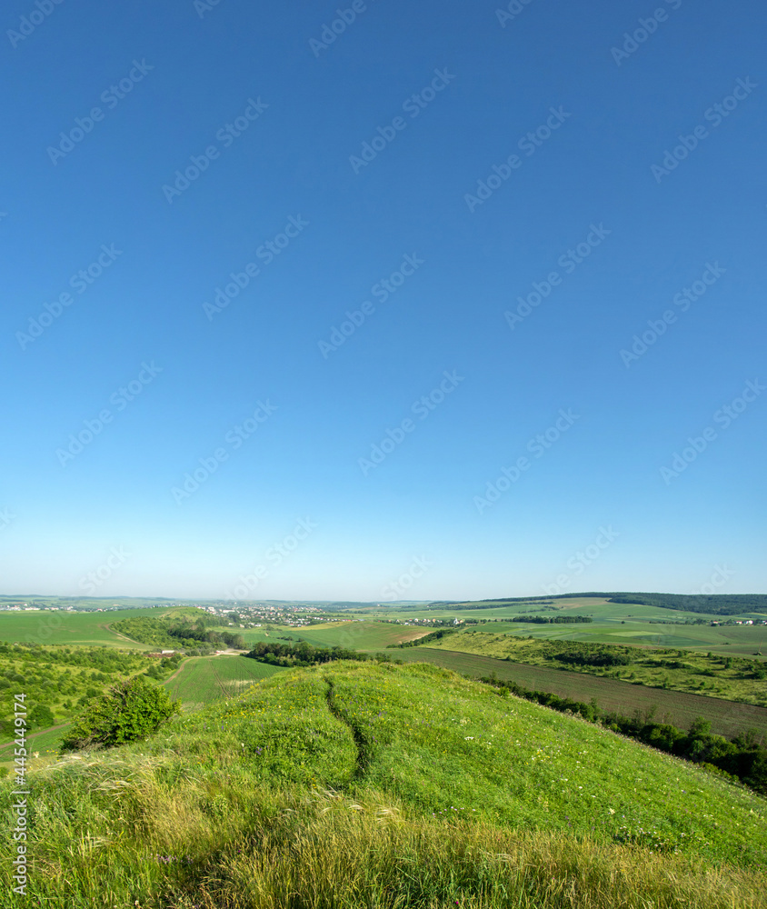 Naklejka premium Panorama of meadows, fields and the small town of Rohatyn on a sunny day in summer in Ukraine