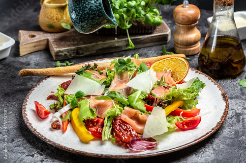 Smoked salmon salad with lettuce, sun-dried tomatoes and herbs, Delicious balanced food concept