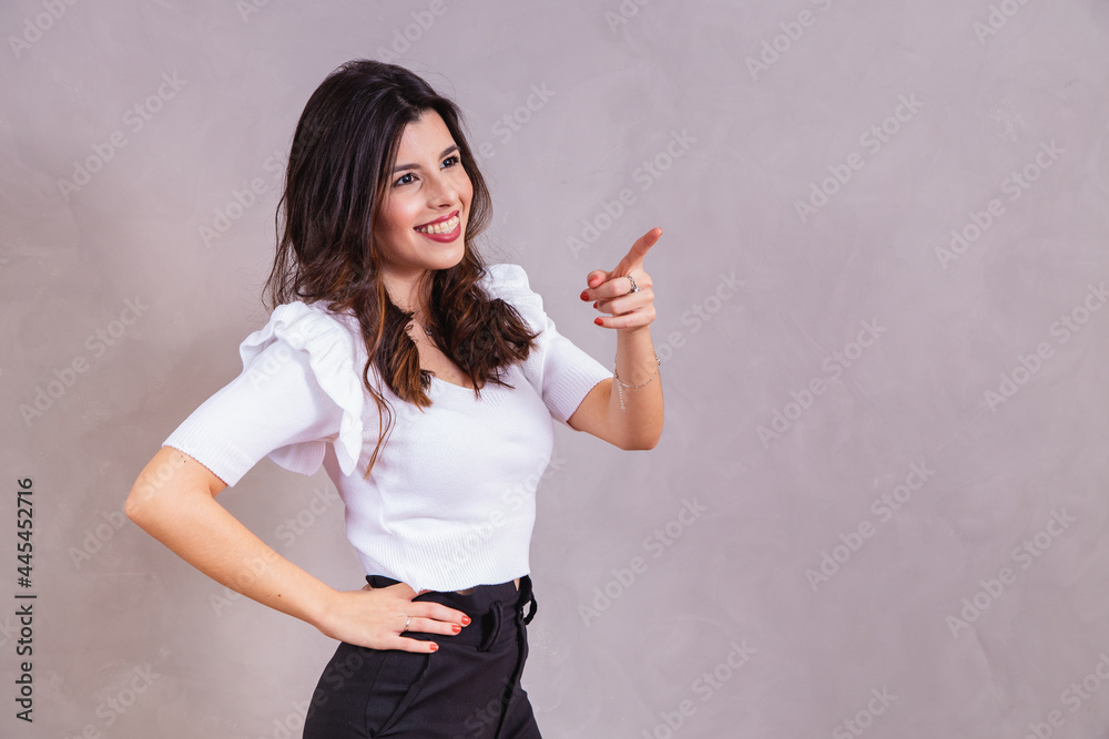Ταπετσαρία Smiling woman pointing her finger diagonally with free space for text