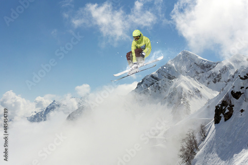 Skier jumps in the mountains. Mountain ski, winter extreme sport.