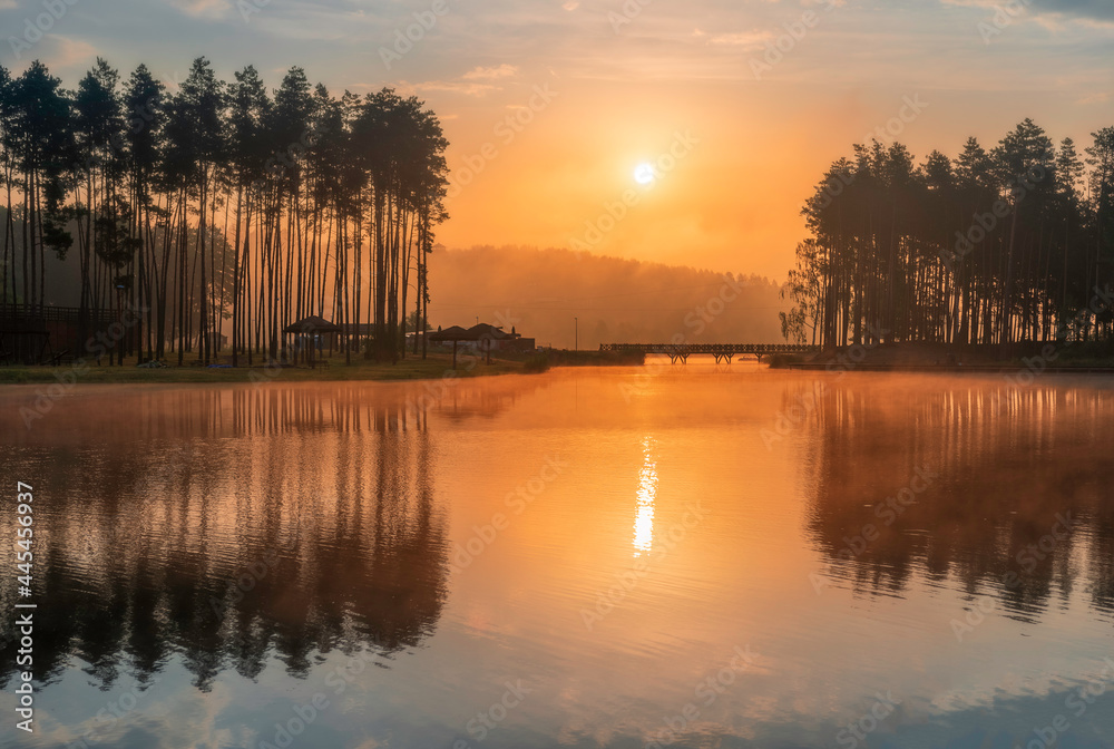 Beautiful sunrise above lake in Krasnobród, Roztocze, Poland. Water surrounded by trees in the morning light.
