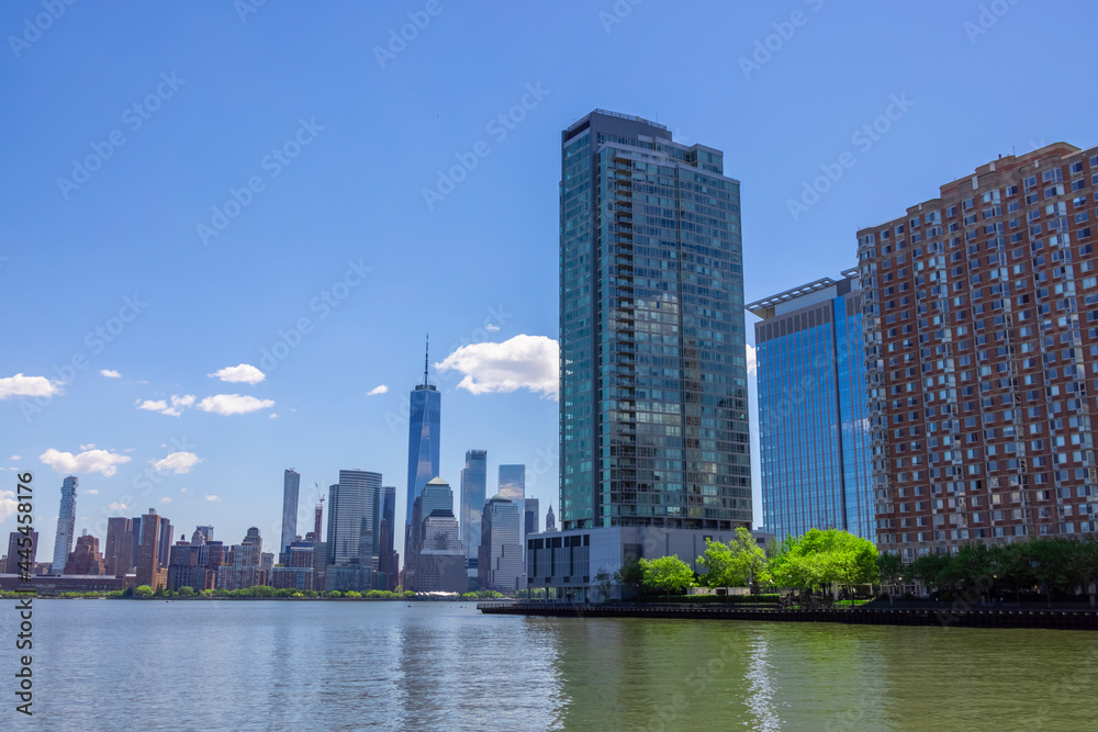 Lower Manhattan skyscraper stands in Manhattan Ward beyond the Hudson River behind the Luxury high-rise apartments at New Jersey Ward in Jersey City USA on May 14 2021.