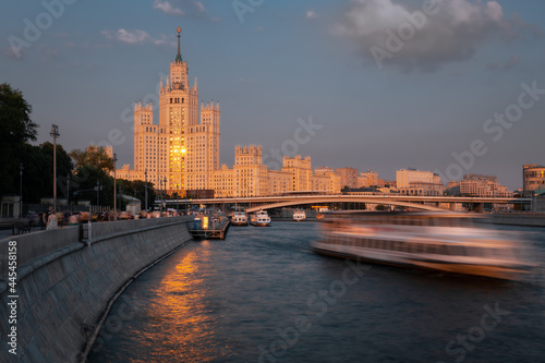 Sunset cityscape featuring brightly lighted empire style skyscraper on a riverbank, Kotelnicheskaya embankment