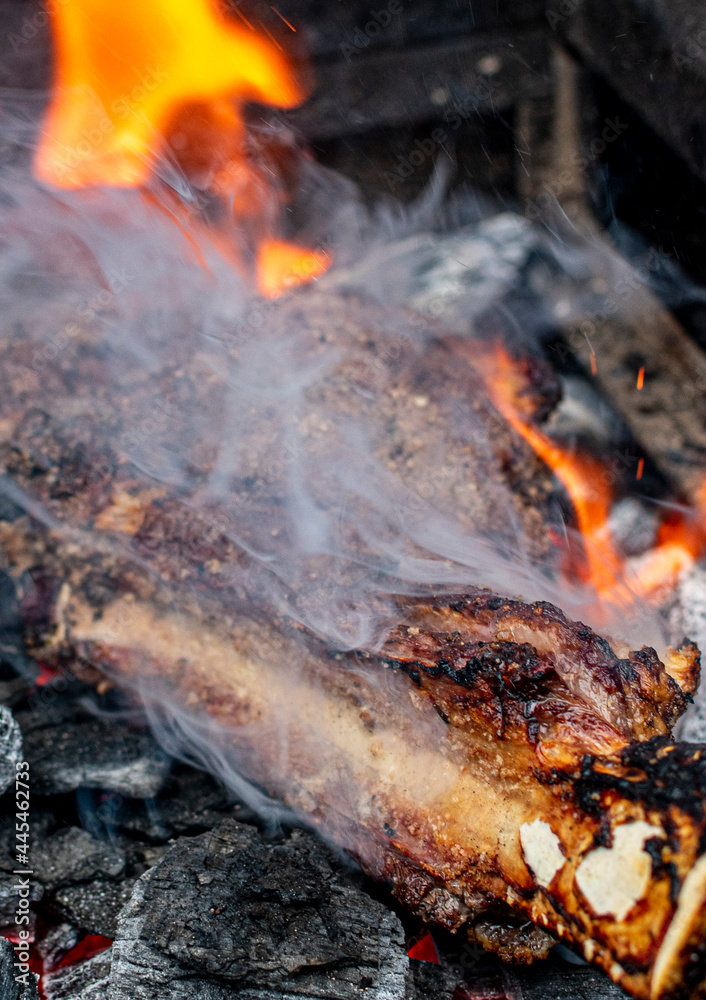 Naklejka premium corte de res directo a las brasas.corte de res cowboy al estilo caveman.corte al carbón directo a las brasa estilo cavernícola