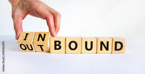 Inbound or outbound symbol. Businessman turns wooden cubes and changes the word 'outbound' to 'inbound'. Beautiful white table, white background. Business, inbound or outbound concept. Copy space. photo