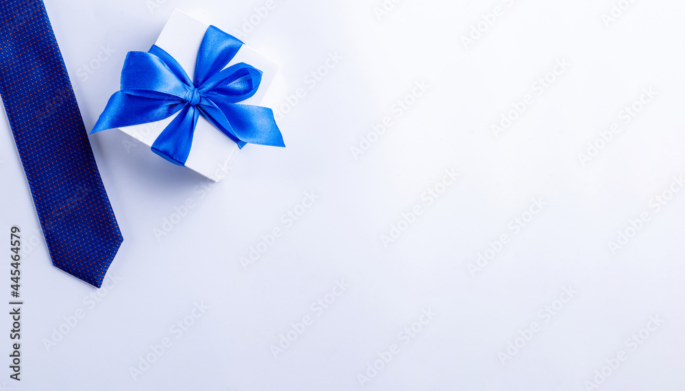 Gift father day. Blue bowtie or tie, white box with bow ribbon on light background. Happy loving family and Fathers Day concept. Gift father day. Blue bowtie or tie, white box with bow ribbon on light background. Happy loving family and Fathers Day concept.
