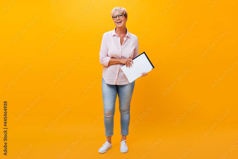 Portrait of business lady in jeans and shirt on orange background Portrait of business lady in jeans and shirt on orange background