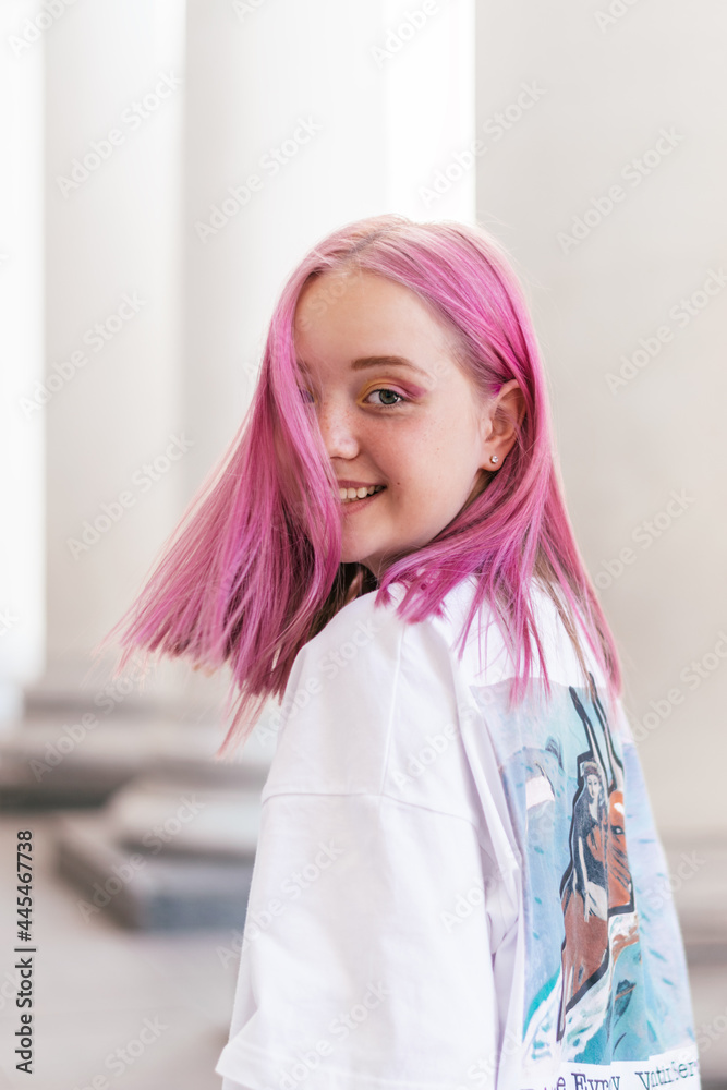 Portrait of a positive pink-haired teenage girl in a white T-shirt.Street style.Summer concept.Generation Z style.