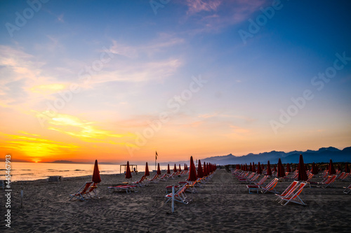 Fototapeta Naklejka Na Ścianę i Meble -  spiaggia al tramonto 03 - ombrelloni, spiaggia e mare nella luce del tramonto