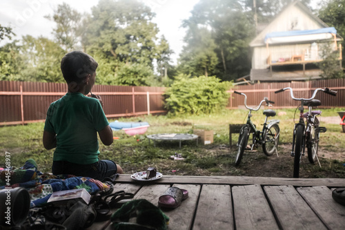 Boy sitting and looking at bicycles in morning light daylight