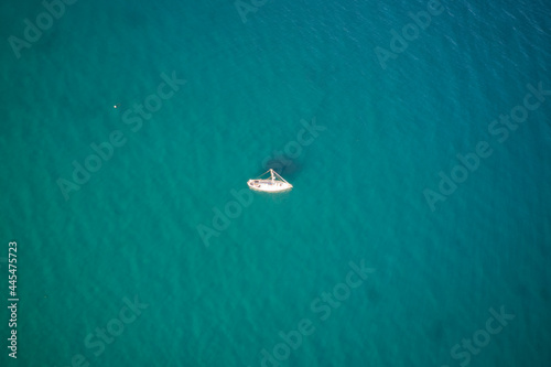 A high definition aerial view of a sailboat in the ocean.