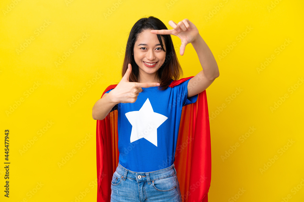 Super hero Vietnamese woman isolated on yellow background focusing face. Framing symbol Super hero Vietnamese woman isolated on yellow background focusing face. Framing symbol