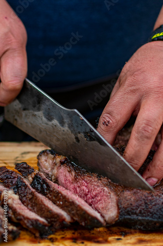 manos con cuchillo haciendo filetes de corte cowboy asado.

manos cortando.

filetes de cowboy.

manos fileteando.