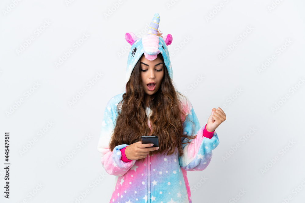 Young caucasian woman wearing a unicorn pajama isolated on white background surprised and sending a message