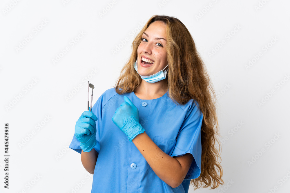 Woman dentist holding tools isolated on white background celebrating a victory Woman dentist holding tools isolated on white background celebrating a victory