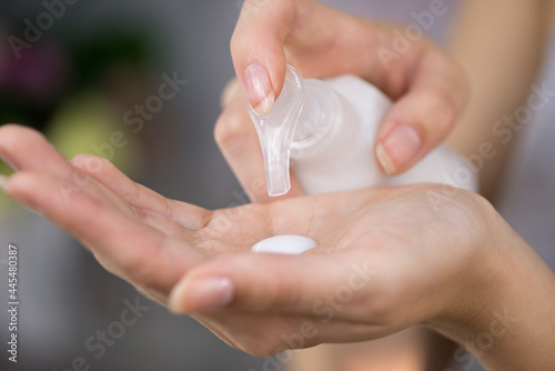 Woman's hand apply soap, gel, cream or hand cleansing sanitizer liquid, close up. Hygiene and skin care. Infection prevention. Selective focus