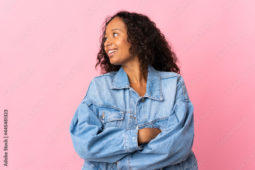 Fototapeta premium Teenager cuban girl isolated on pink background looking to the side