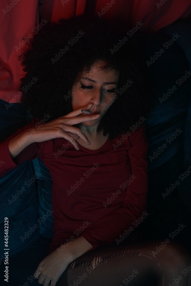young curly hair woman smoking at night young curly hair woman smoking at night